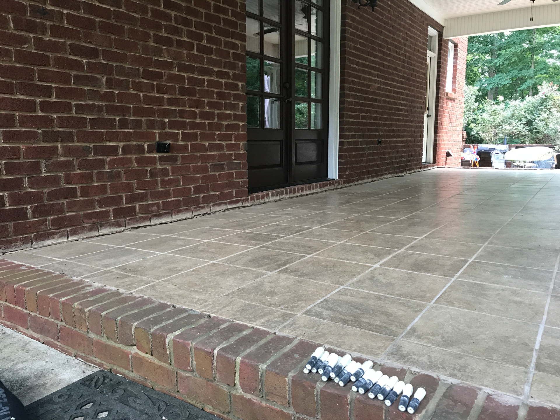 Sinking concrete patio with tile and brick - before